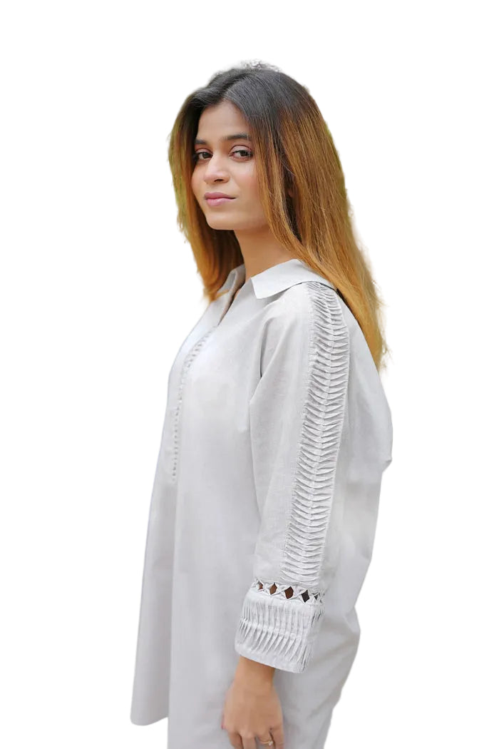 Woman wearing a white outfit with intricate detailing in an outdoor setting
