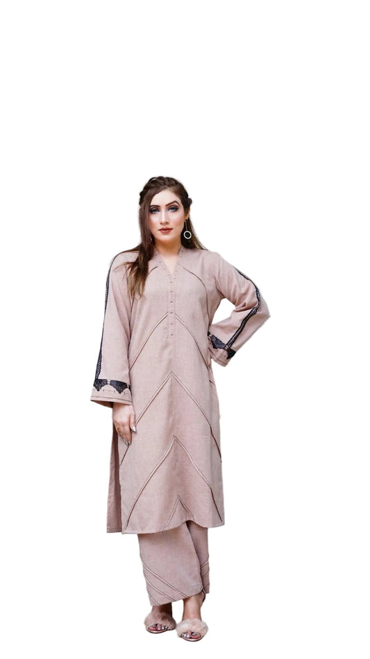 Woman in a pink traditional outfit standing in a stylish room with decor elements.