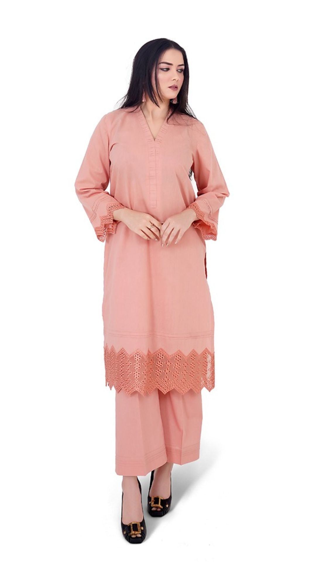 Woman wearing a peach-colored outfit with lace details on a white background