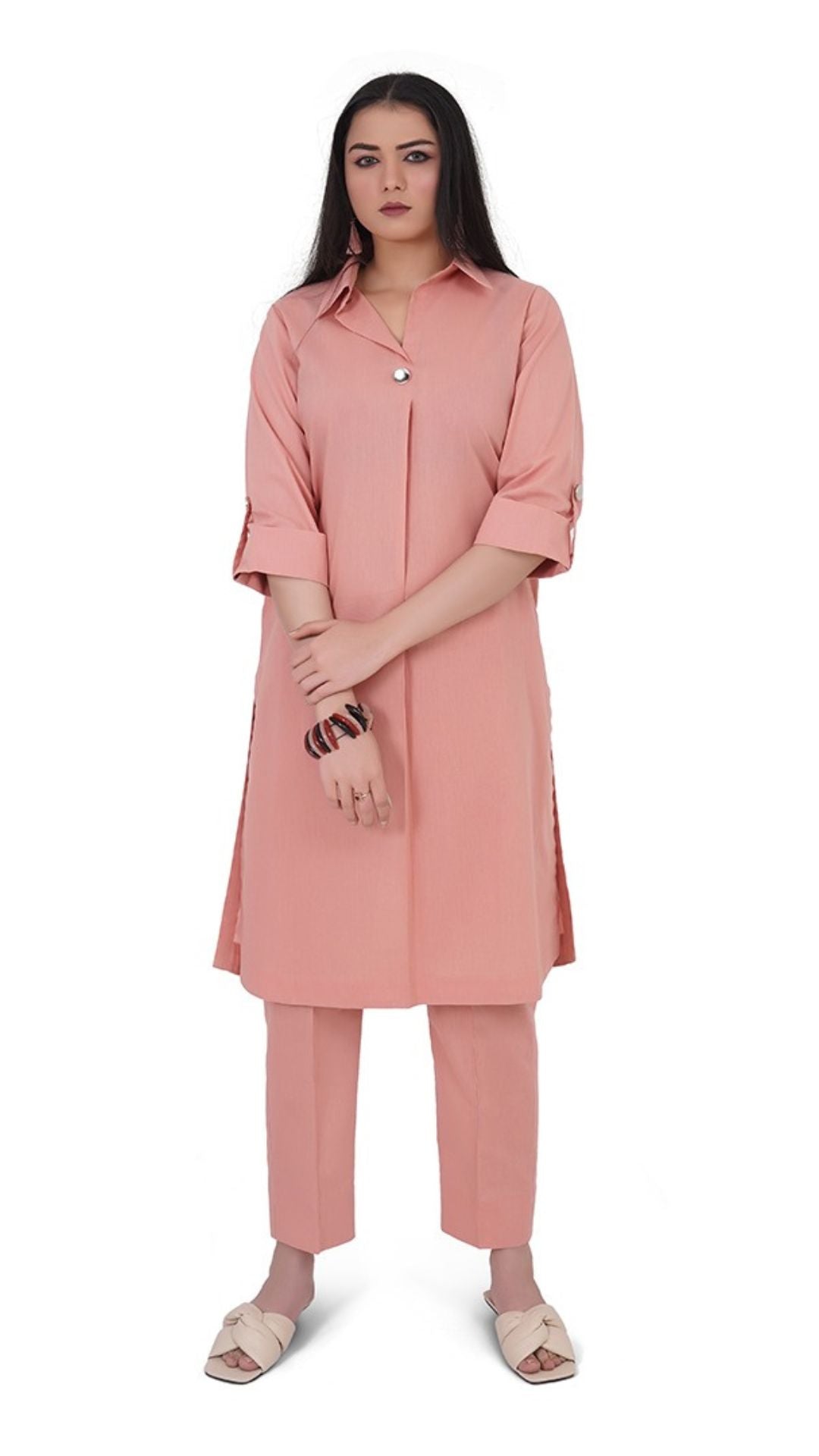 Woman wearing a pink outfit with a long shirt and pants on a white background