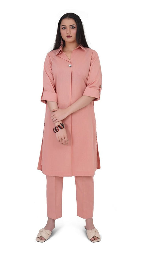 Woman wearing a pink outfit with a long shirt and pants on a white background